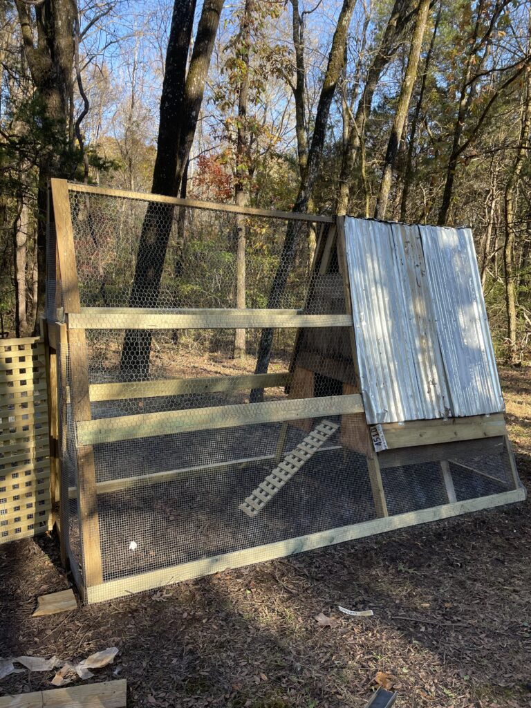 An A-frame chicken coop with run. 