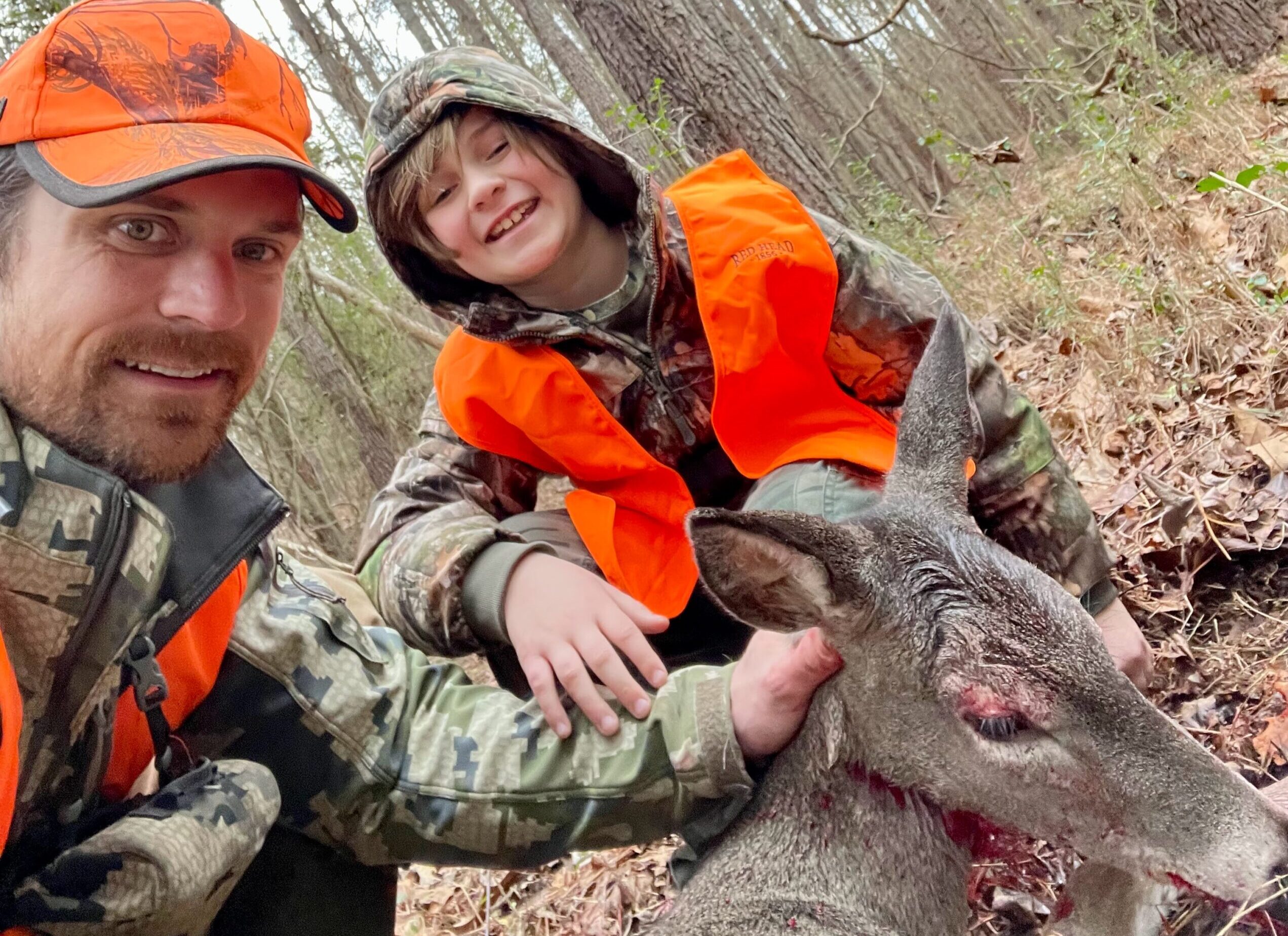 Father and son pose after a successful doe hunt.